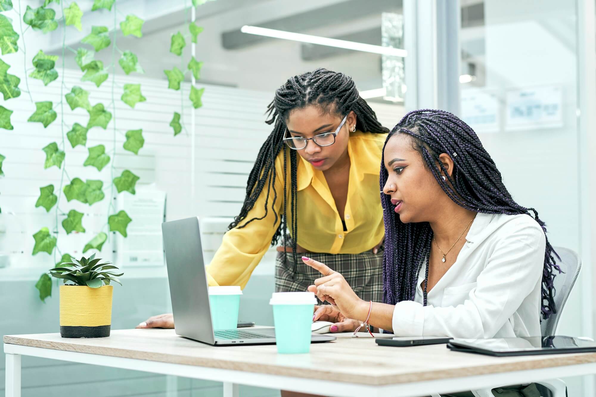 two young black women reviewing analytical data on various electronic devices .jpg